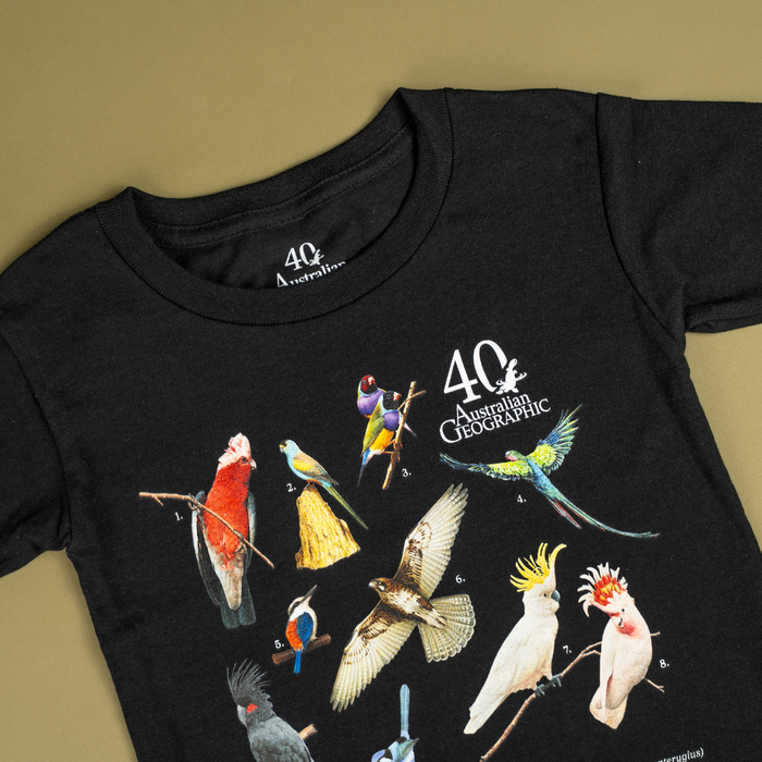 Black t-shirt with colorful bird illustrations and 40 Australian Geographic logo on a beige background
