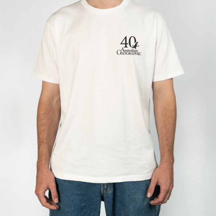 Person wearing a white t-shirt with a logo and text on a plain background