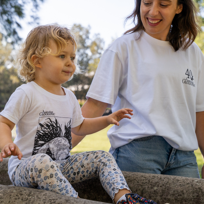 Woman and child wearing white t-shirts with logos outdoors