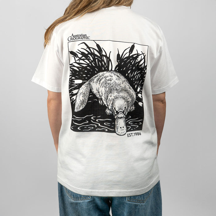 Person wearing a white t-shirt with a graphic of a platypus and text on the back, on a plain background.