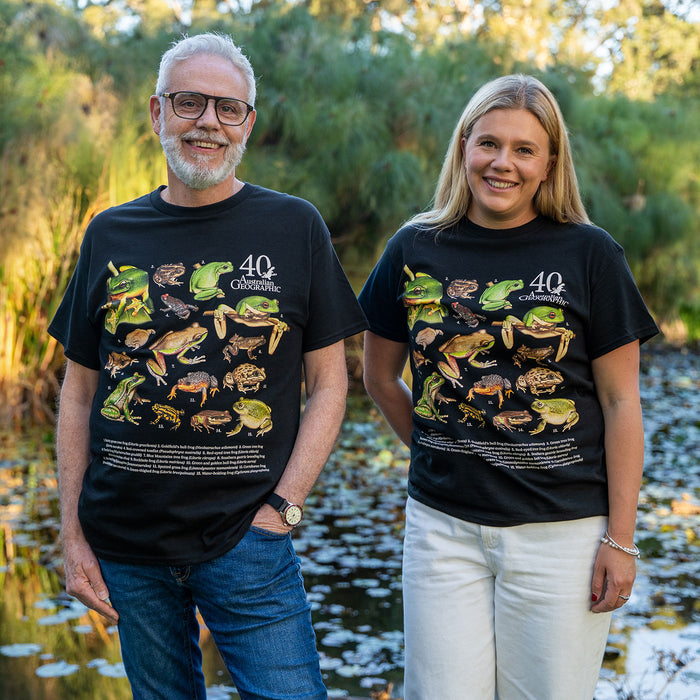 Two people wearing black t-shirts with frog illustrations outdoors.