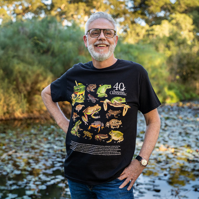 Person standing in a nature setting in a black t-shirt with Australian frogs