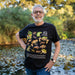 Person standing in a nature setting in a black t-shirt with Australian frogs