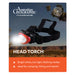 An Australian Geographic magazine cover featuring a head torch with a bright white flashlight on the front and a red accent ring. The cover includes the Australian Geographic logo, a compass emblem, and text highlighting features like bright white light, low light, flashing modes, and suitability for camping, hiking, and repairs.