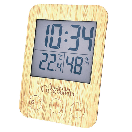 A digital climate control thermometer with a light natural wood grain frame, featuring a gray LCD screen displaying the time, temperature in Celsius, relative humidity, and percentage RH. The brand name 'Australian Geographic' is printed below the screen, along with three control buttons.