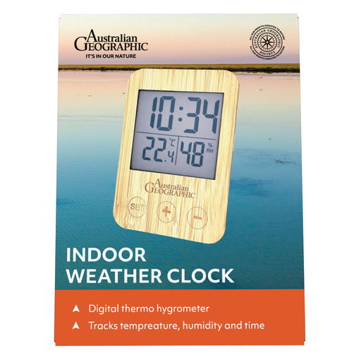 Australian Geographic indoor weather clock in its retail packaging, featuring a digital display with a light wood-grain frame over a scenic lake background.