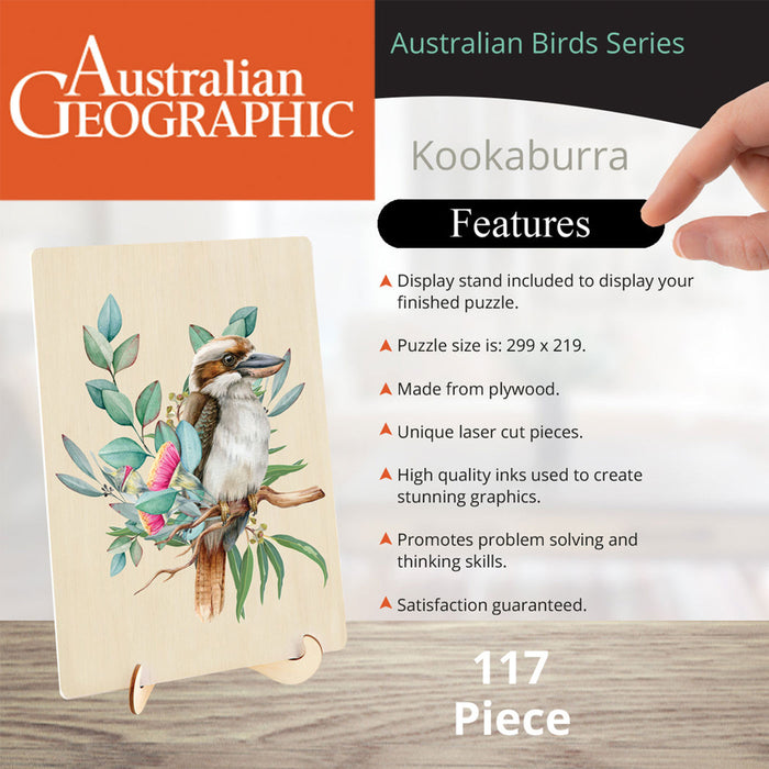 Australian Geographic Kookaburra wooden puzzle in its display stand, featuring a hand pointing to the right side of the image where features are listed, on a light wood tabletop background.