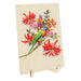 A rectangular wooden plaque or board on a small wooden display stand, featuring a colorful print of two lorikeets among bright red flowers on a light wood background.