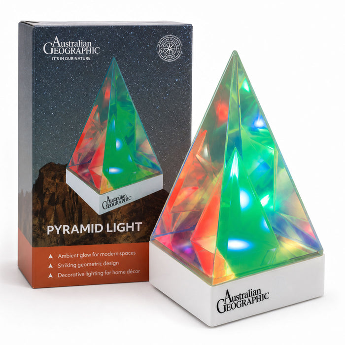 Australian Geographic Pyramid Light and its retail box, featuring a faceted crystal pyramid lamp glowing with multicolor light on a white base, set against a clean white background.