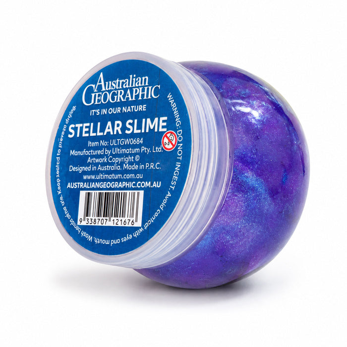 A round plastic tub of Australian Geographic Stellar Slime, showing a deep purple and blue glittery slime inside. The lid is turned to the side to reveal a blue label with product details and a barcode.