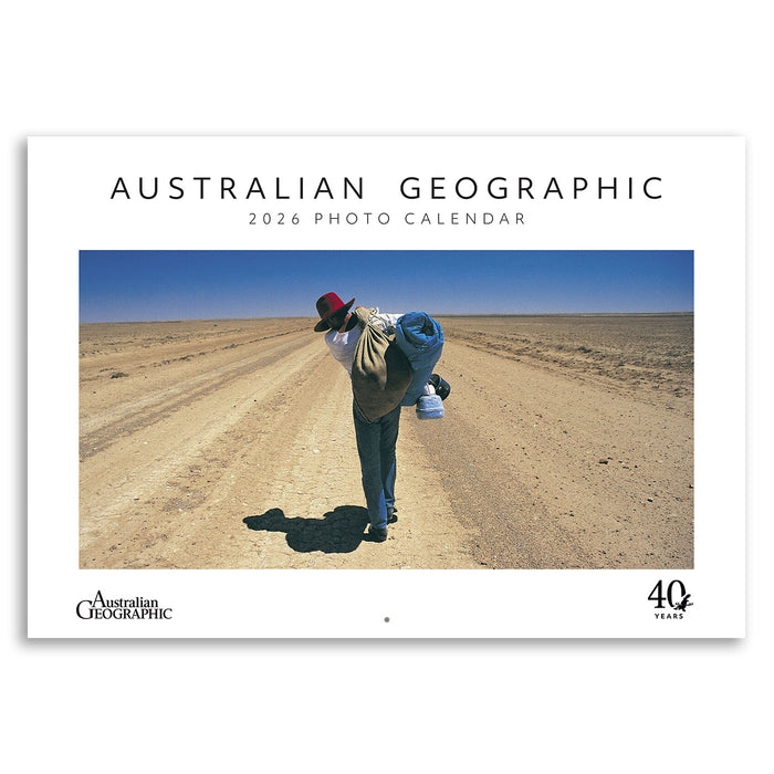 Australian Geographic 2026 photo calendar cover with a person in a hat and coat standing on a dirt road.