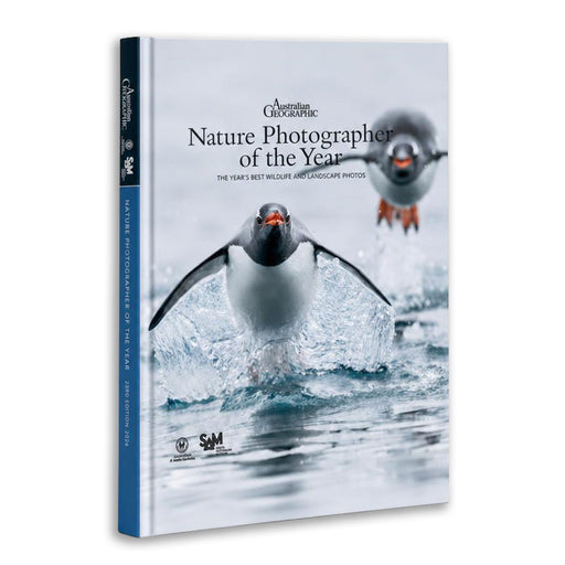 A hardcover book titled "Nature Photographer of the Year" by Australian Geographic, featuring a penguin splash photograph on the cover and a blue spine, shown on a white background.