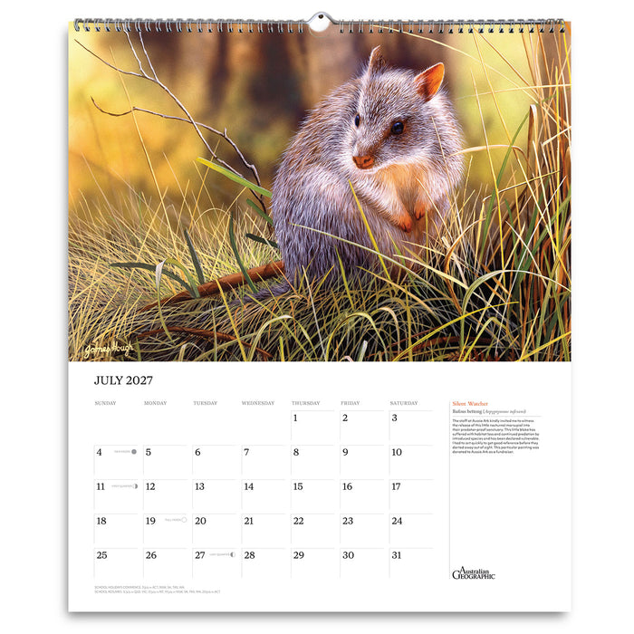 A spiral-bound wall calendar page showing a photographic wildlife scene of a gray and orange rodent in tall grass, with a July 2027 calendar grid and text on the lower white section.