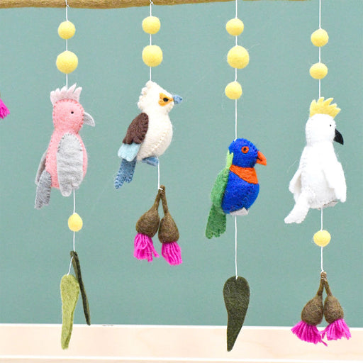 Colorful bird-themed mobile with hanging toys against a light blue background