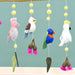 Colorful bird-themed mobile with hanging toys against a light blue background
