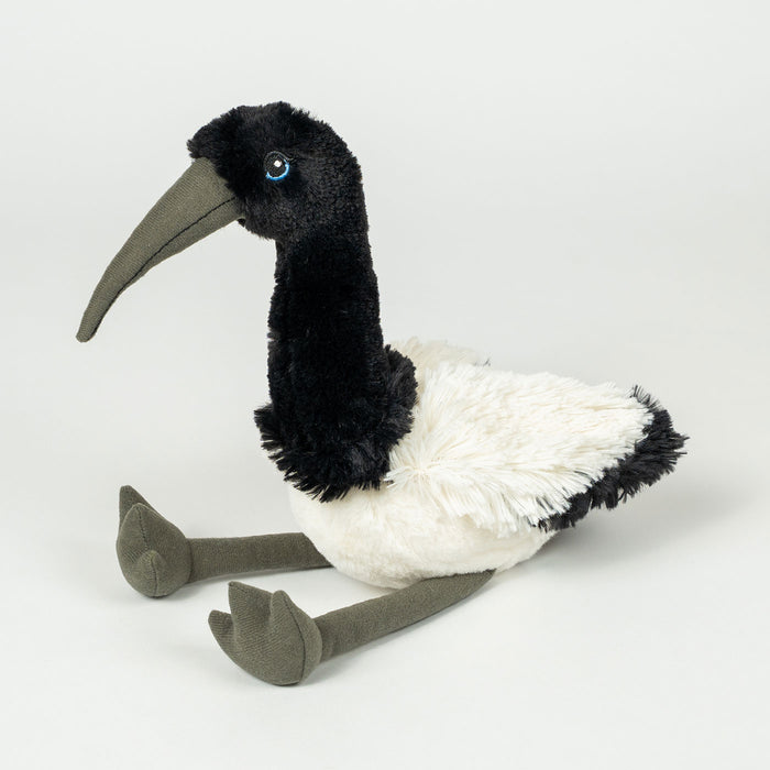 A plush stuffed bird toy with a long curved gray beak, black head and neck, white body, and gray legs and feet, photographed on a clean light gray studio background.