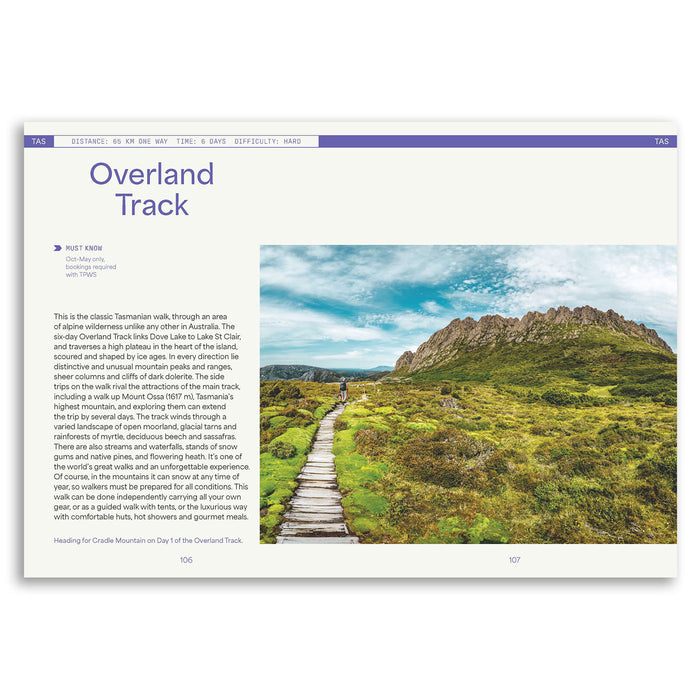 A printed travel guide or magazine page titled 'Overland Track' showing a scenic photograph of a mountain trail, with descriptive text on a white page and a purple header bar.