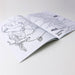 Open coloring book with illustrations of a Tasmanian Devil on a white surface