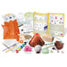 Science experiment kit with volcano model, tools, and educational materials on a white background