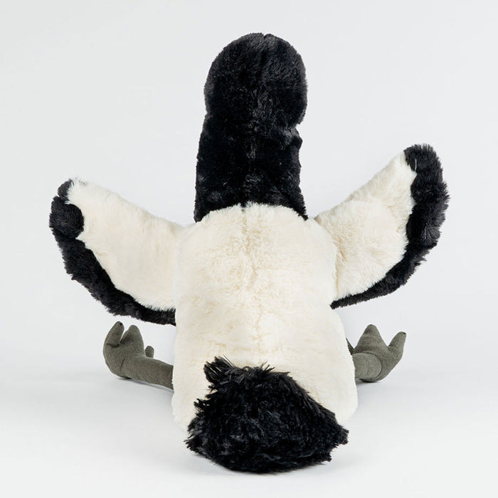 Plush toy ibis with black and white fur on a light gray background