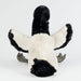 Plush toy ibis with black and white fur on a light gray background