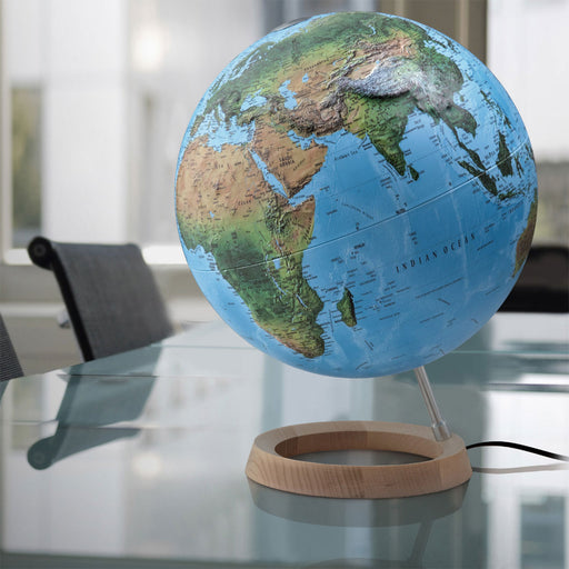 Globe on a wooden stand with a blurred office background