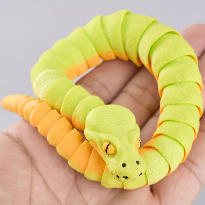Green and orange snake-shaped toy held in a hand against a gray background