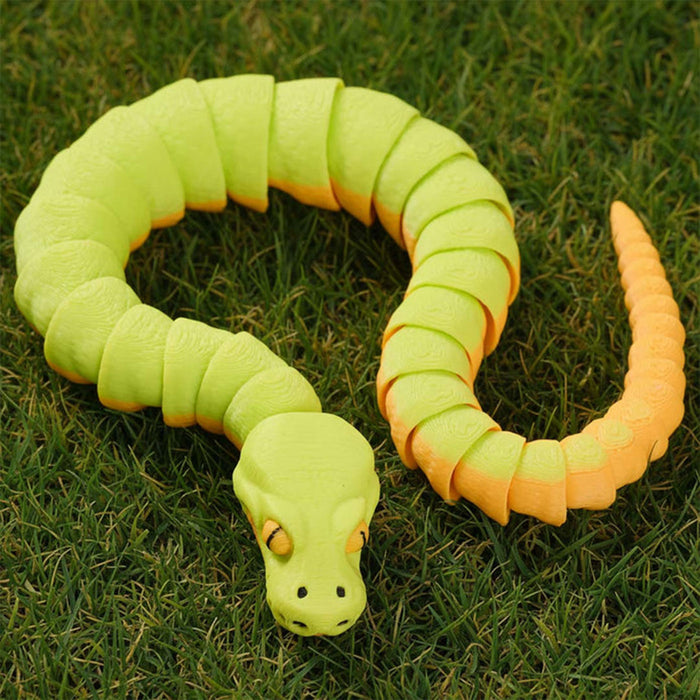 Toy snake with green and orange segments on grass