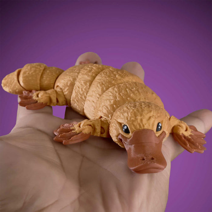 Toy platypus on a hand against a purple background