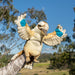Plush toy penguin with outstretched wings held by a person against a natural background