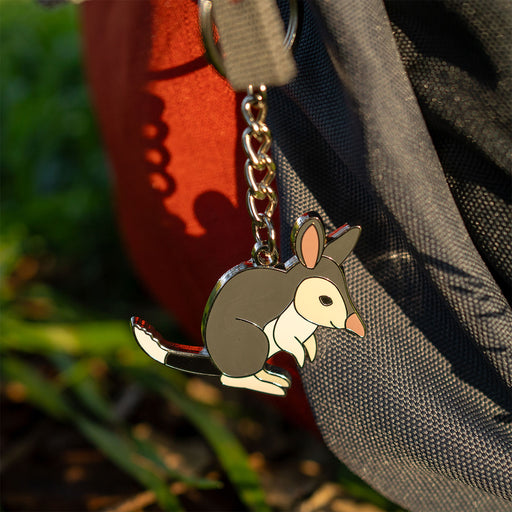 Keychain with a bilby design attached to a bag outdoors.