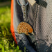 Keychain shaped like an echidna attached to a backpack outdoors