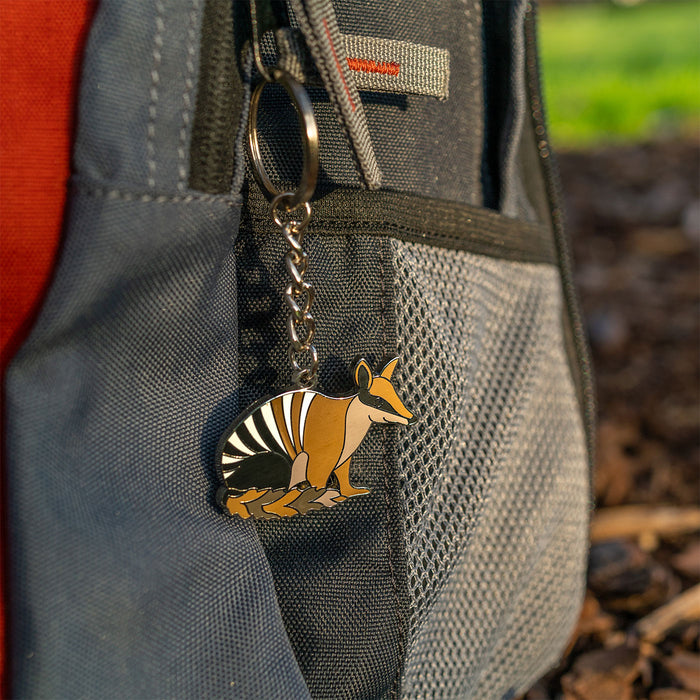 Keychain with a numbat design attached to a backpack