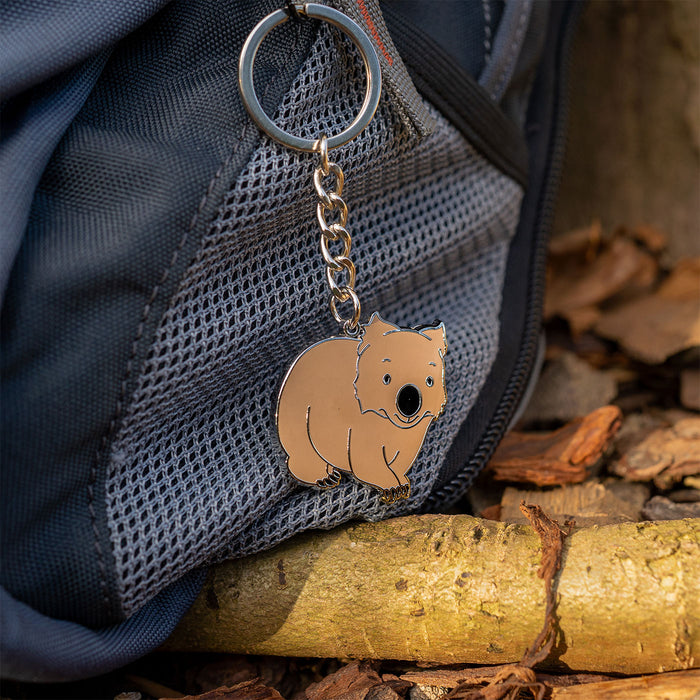 Keychain with a wombat design attached to a backpack on a natural background