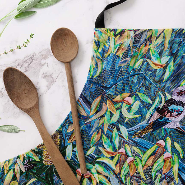 Wooden spoons on a colorful towel with bird and leaf design