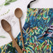 Wooden spoons on a colorful towel with bird and leaf design