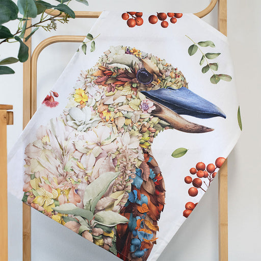 Decorative tea towel with a floral kookaburra design on a wooden stand.