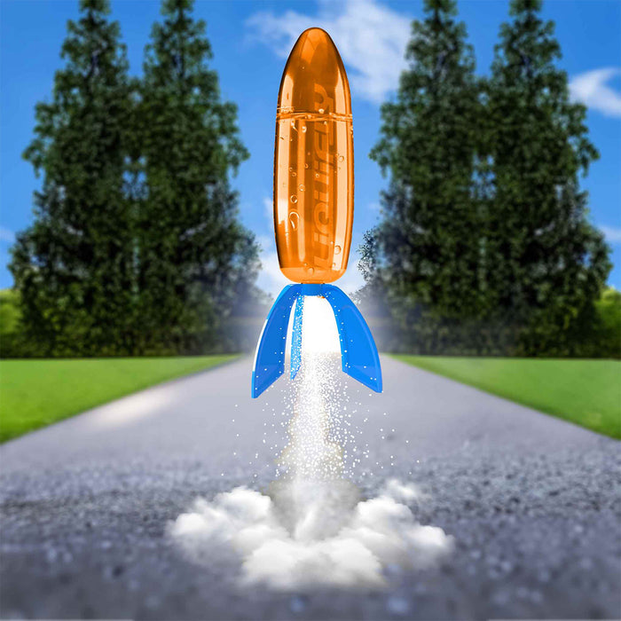 Toy rocket launching on a road with trees in the background