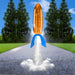 Toy rocket launching on a road with trees in the background