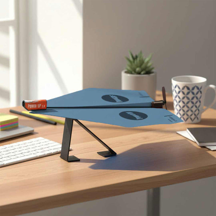 Blue adjustable desk stand on a wooden desk with a mug and stationery items.