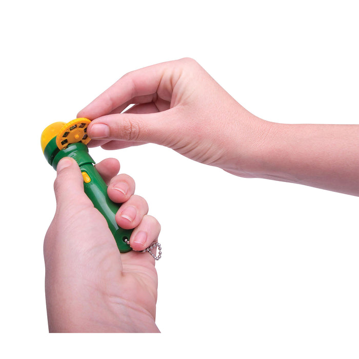Hand holding a green and yellow toy with a white background