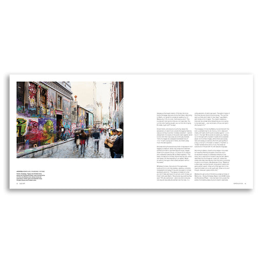 Book open to a page with a street scene and text on a white background