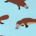 Close-up of a knitted fabric with a repeating platypus pattern on a light blue background.
