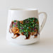 White mug with a decorative design of a wombat covered in flowers and leaves on a white background