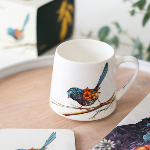 White mug with bird design on a wooden surface
