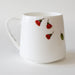 White mug with red floral design on a white background